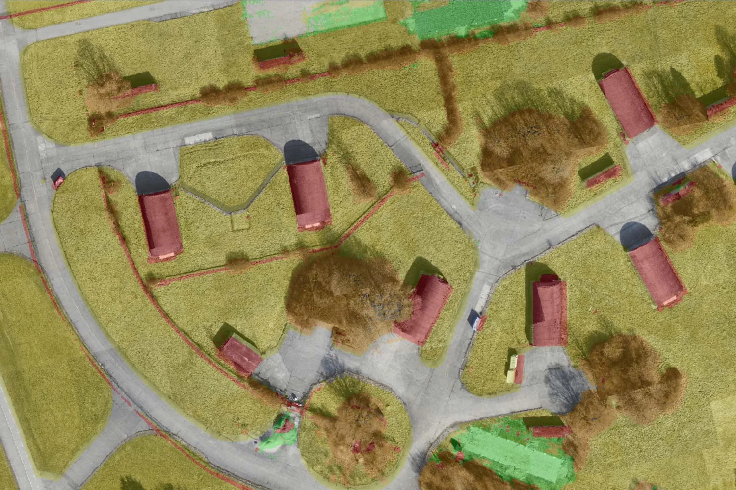 The image shows color coded AI-generated land cover data. Red areas are non-traversable. Green and orange areas are grass and fields. Grey areas are paved areas.