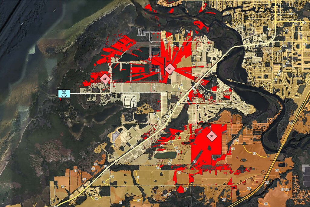 The image shows a map of a coastal area. Areas in red show enemy line of sight. 